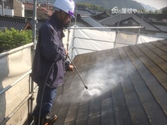 屋根の汚れを高圧洗浄で落とす作業