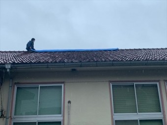 屋根にブルーシートをかけて雨養生
