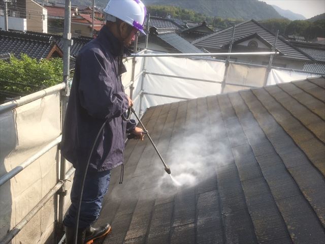 屋根の汚れを高圧洗浄で落とす作業